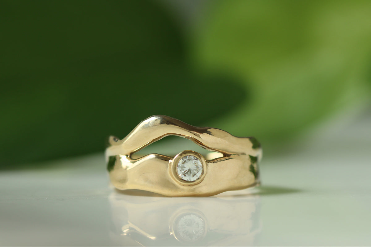 gold organic wavy ring with bezel set round diamond. 